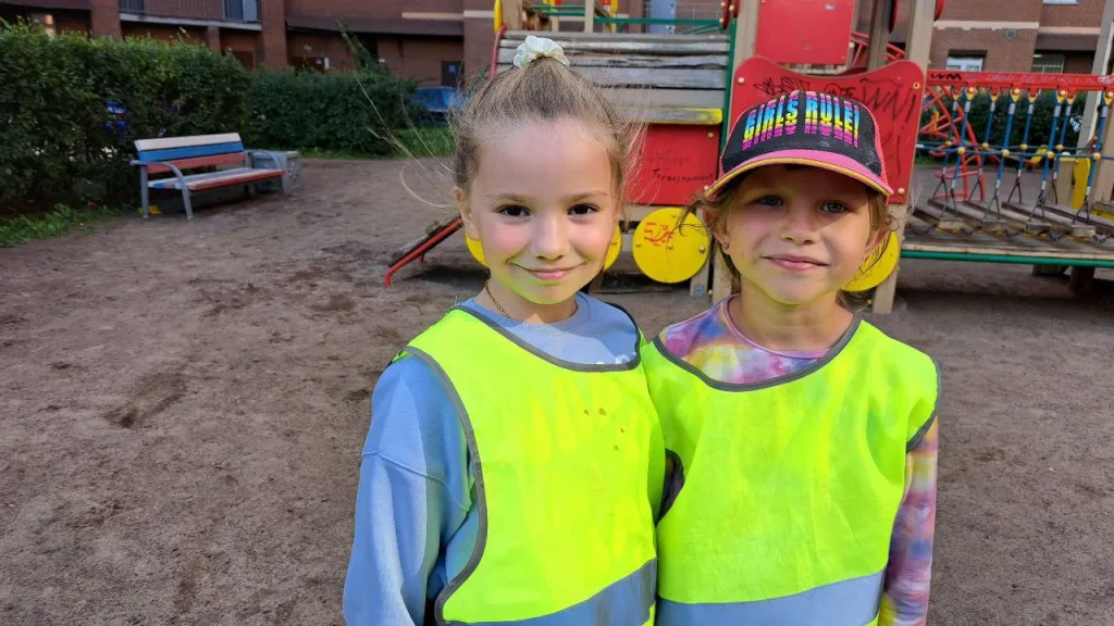 Две девочки 6–8 лет в светоотражающих жилетах на детской площадке во время РобоКаникул — Лига Роботов, Екатеринбург