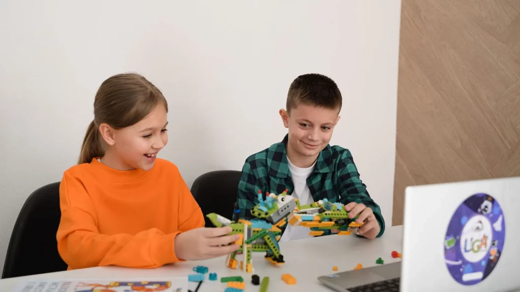 Девочка и мальчик собирают робота из LEGO Education у ноутбука на занятии Лиги Роботов, Екатеринбург