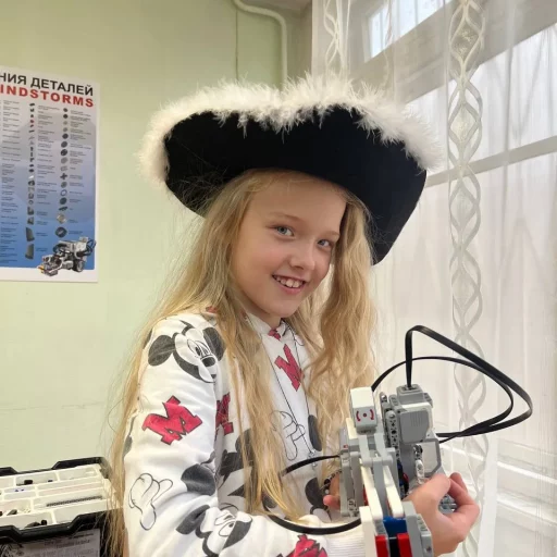 Девочка в пиратской шляпе держит собранного робота LEGO Mindstorms EV3 на занятии в Лиге Роботов, Екатеринбург