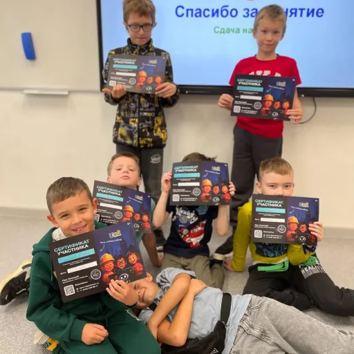 Группа детей в Лиге Роботов (Екатеринбург) держит сертификаты участника на фоне экрана «Спасибо за занятие»